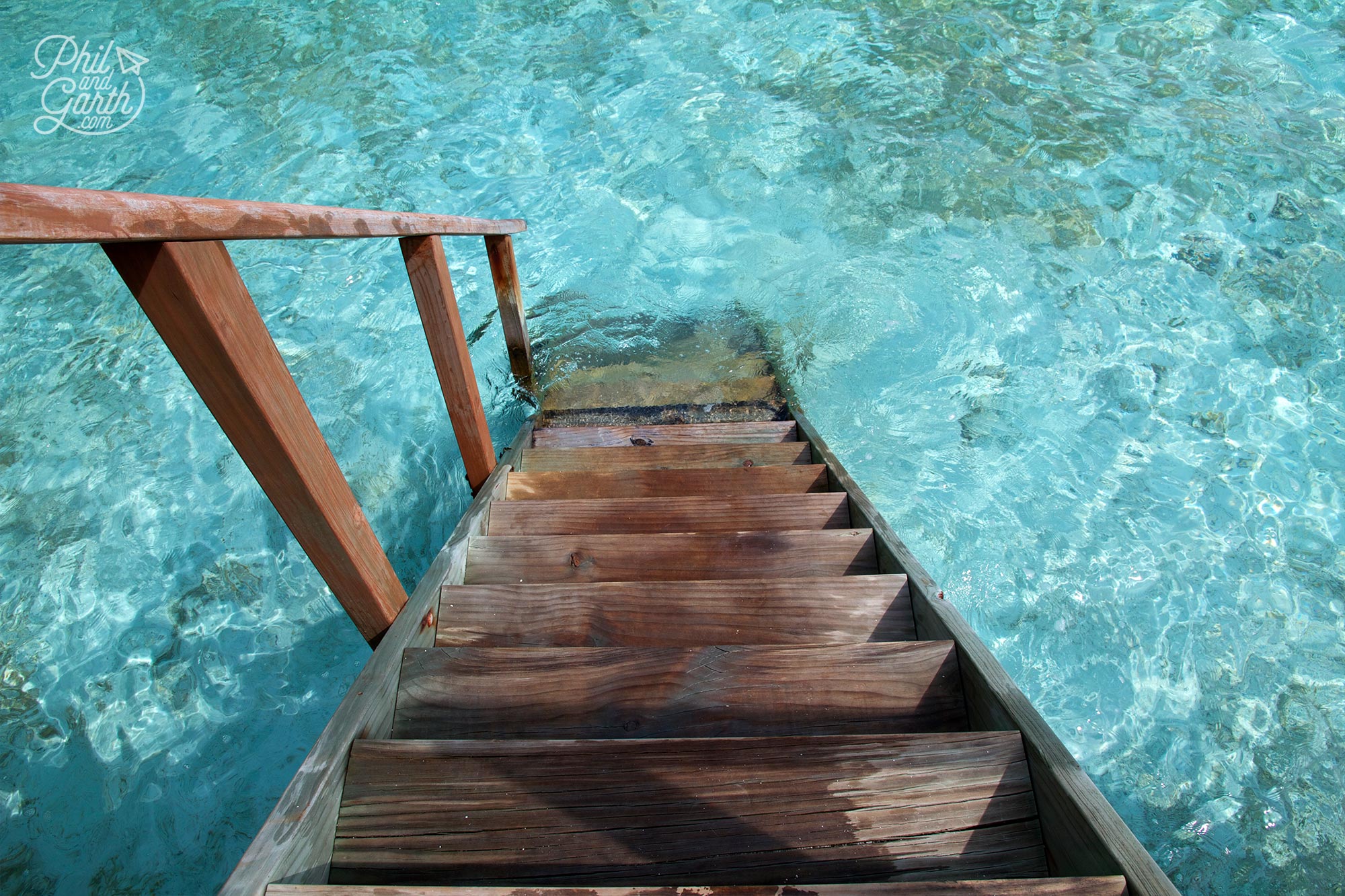 The steps down from our jacuzzi water villa straight to the water. Look at that colour!