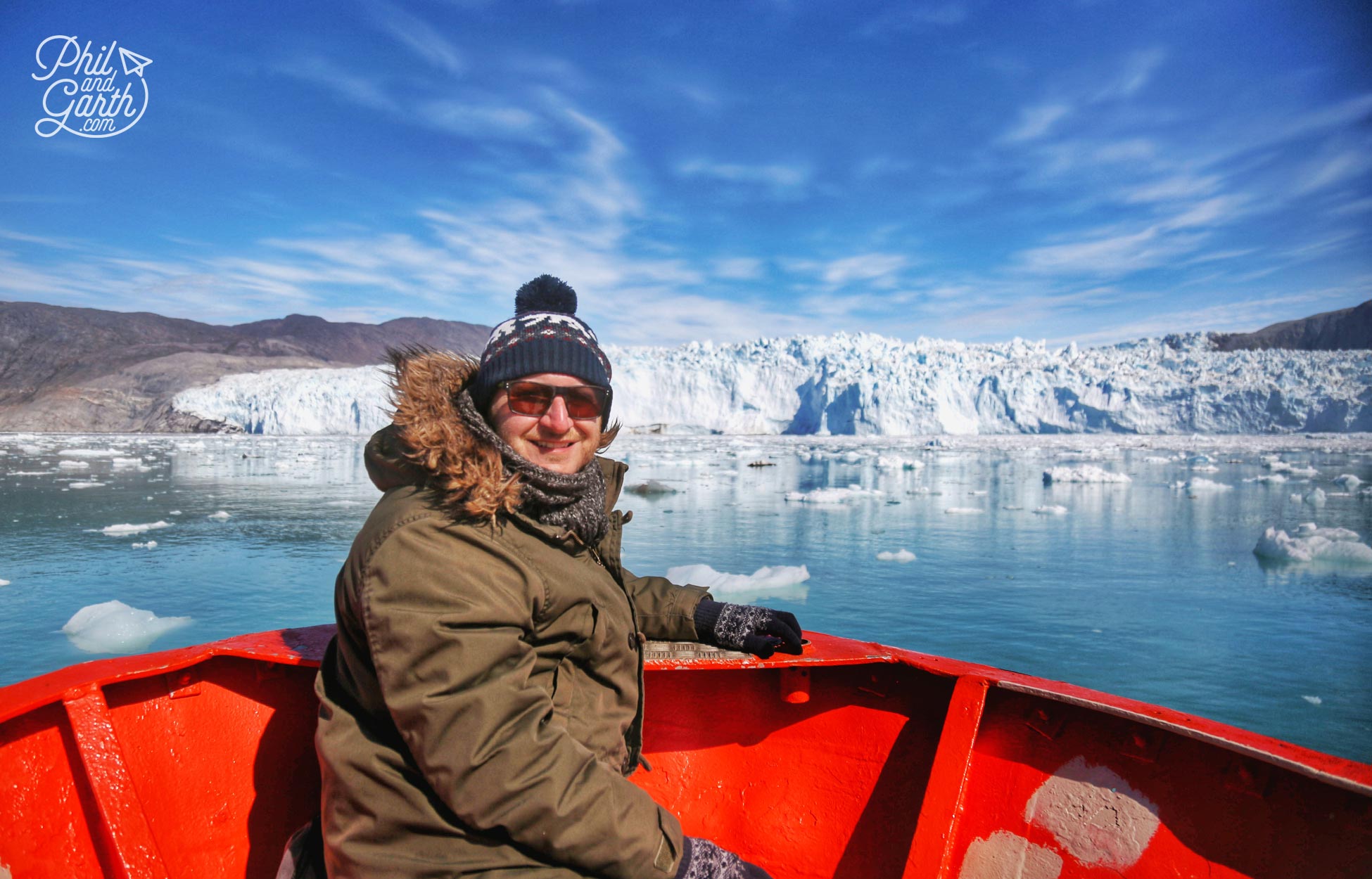 Garth approaching the Eqi Glacier by boat, with hat, gloves scarf and long johns!