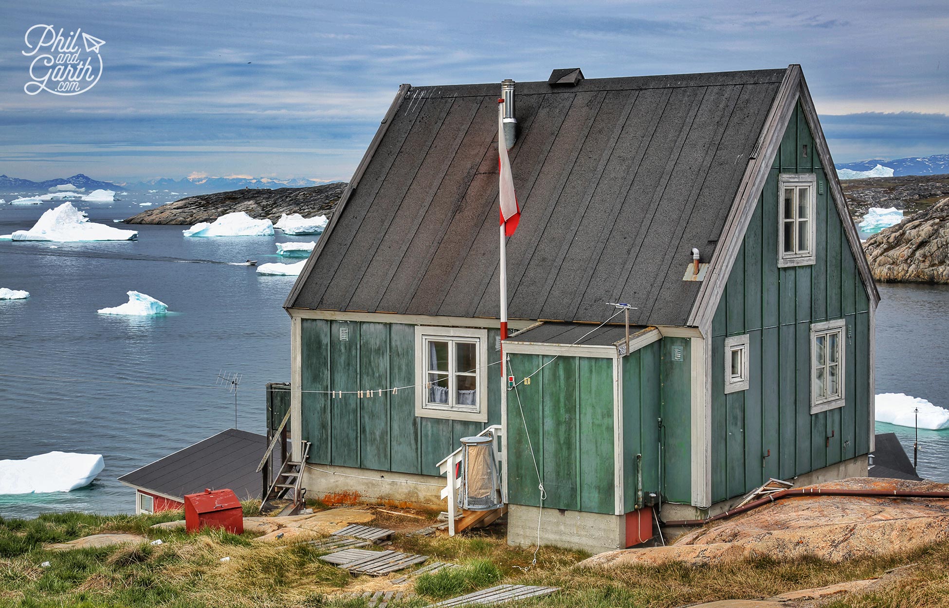 A lone house with the icebergs in Disko Bay, Ilulissat, Greenland