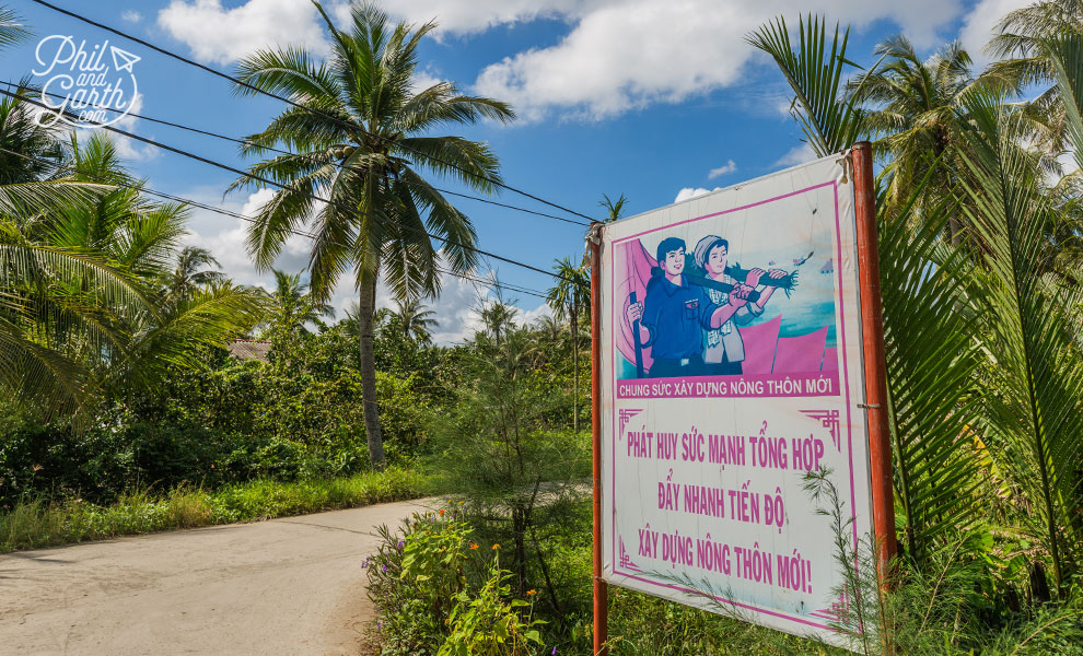 Propaganda poster says something like "Joint efforts to build a new countryside promoting synergy that accelerates rural development"