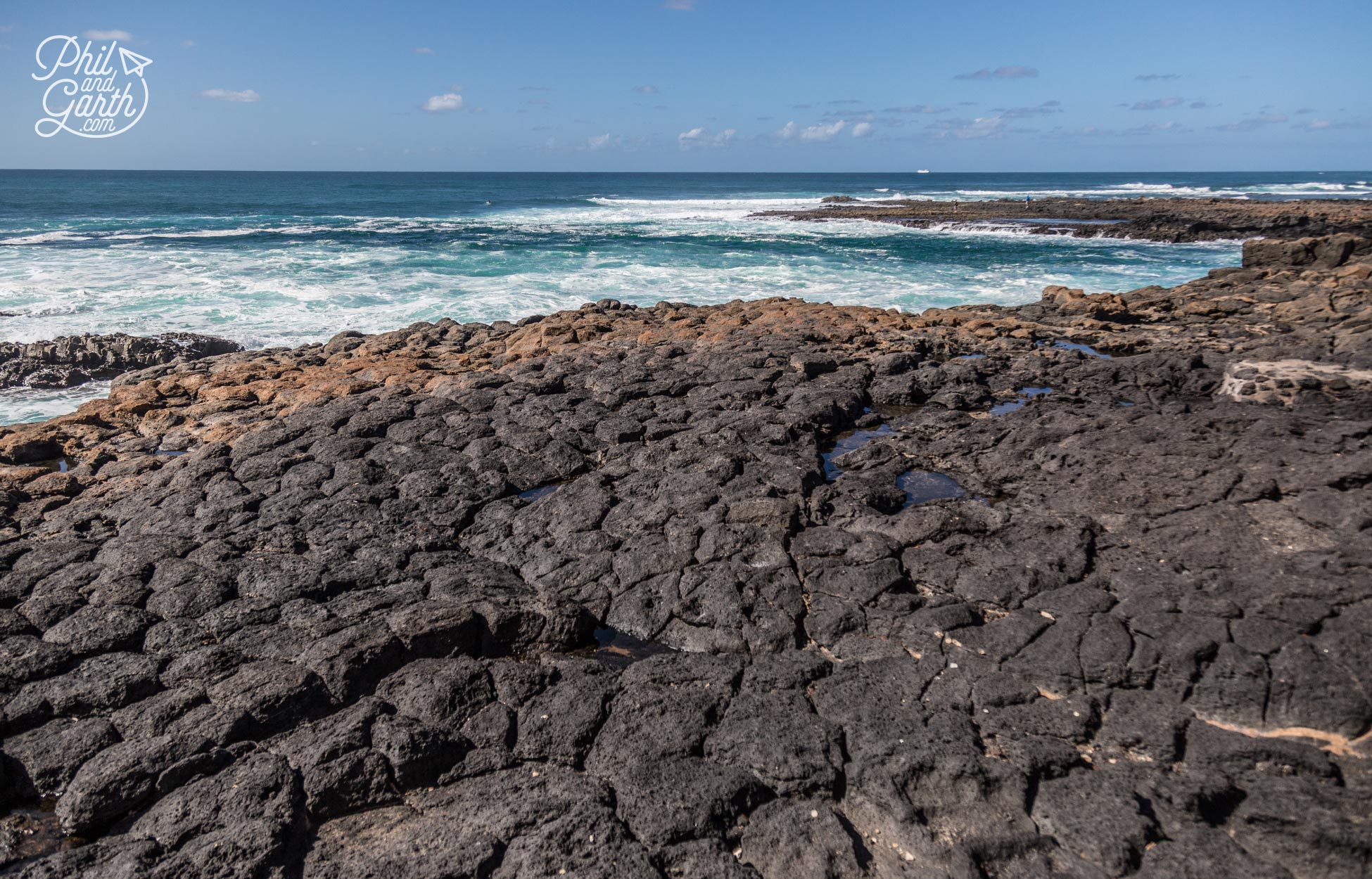 Black volcanic rock meets the sea