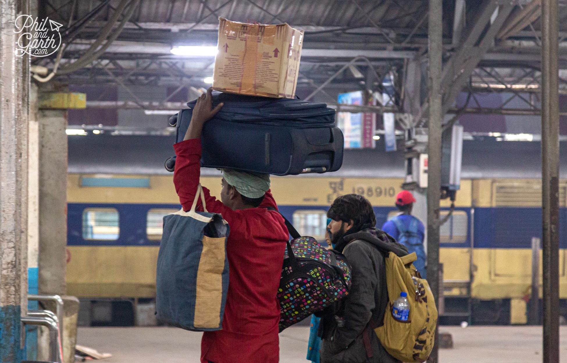 Luggage porters wear red blazers and carry huge loads, even on their heads