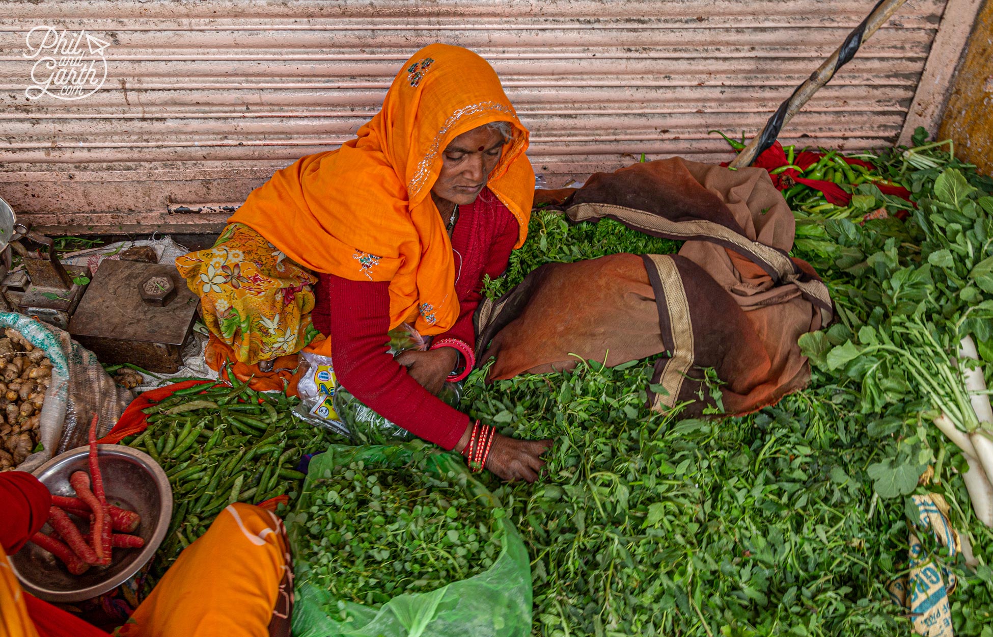 A lady selling fresh herbs and vegetables