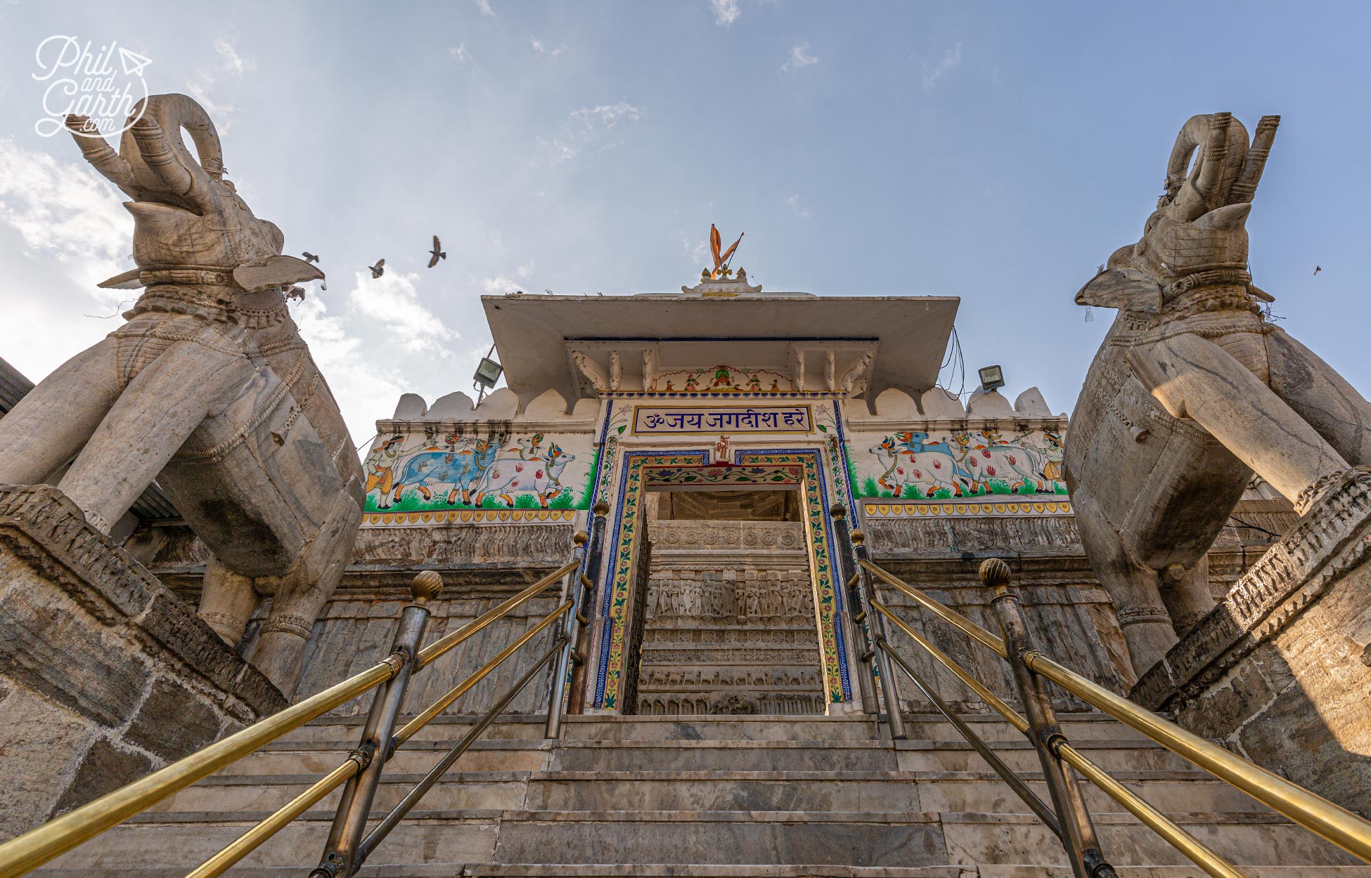 Two massive marble elephants welcome visitors and guard the temple