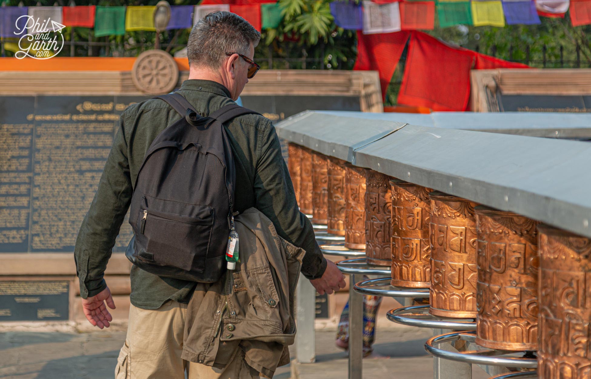 Phil spins the prayer wheels clockwise at the Mulagandha Kuti Vihara temple