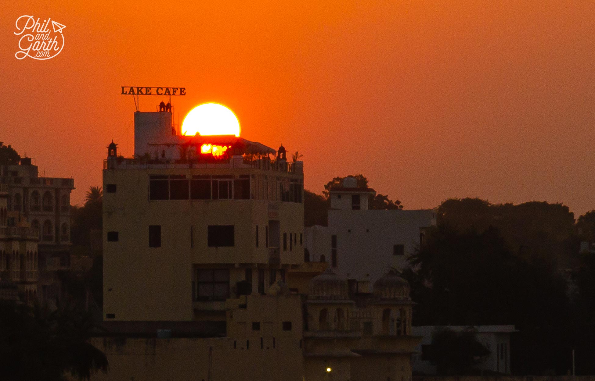 The sun disappearing behind the Lake Cafe in the distance