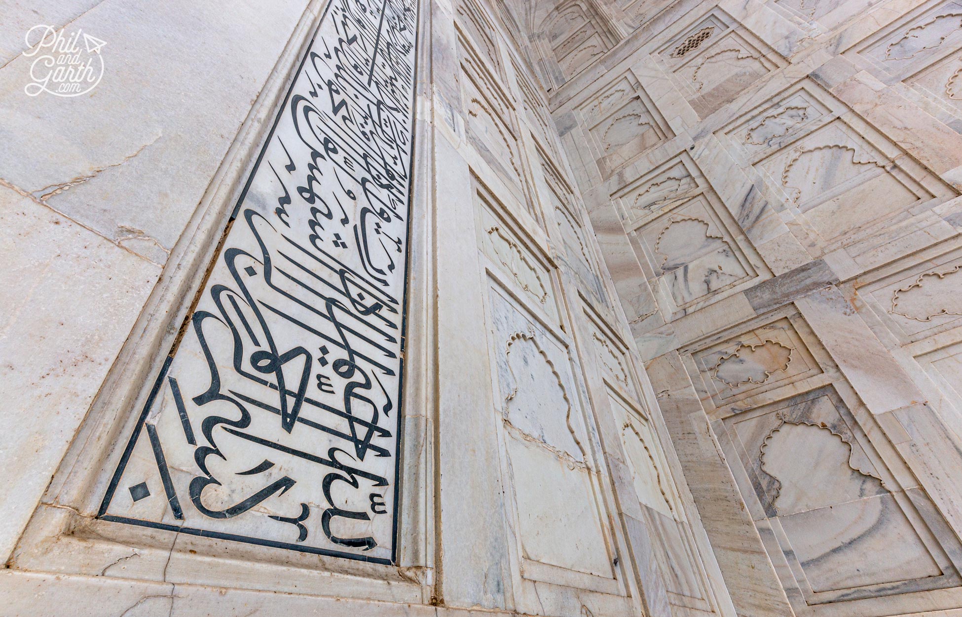 The Arabic calligraphy surrounding the entrance is a verse from the Quran