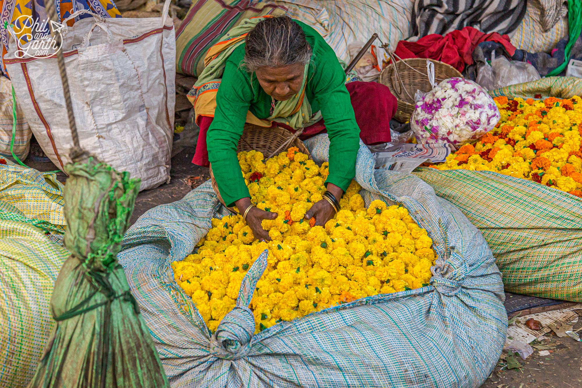 A lady delicately tosses her yellow marigold flowers