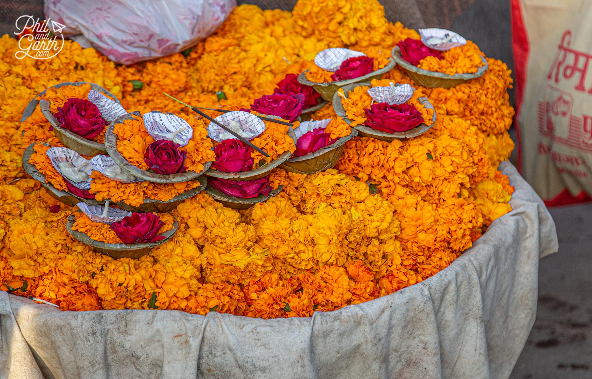 Deepaks for sale - little bowls containing a prayer candle, marigold and rose flowers