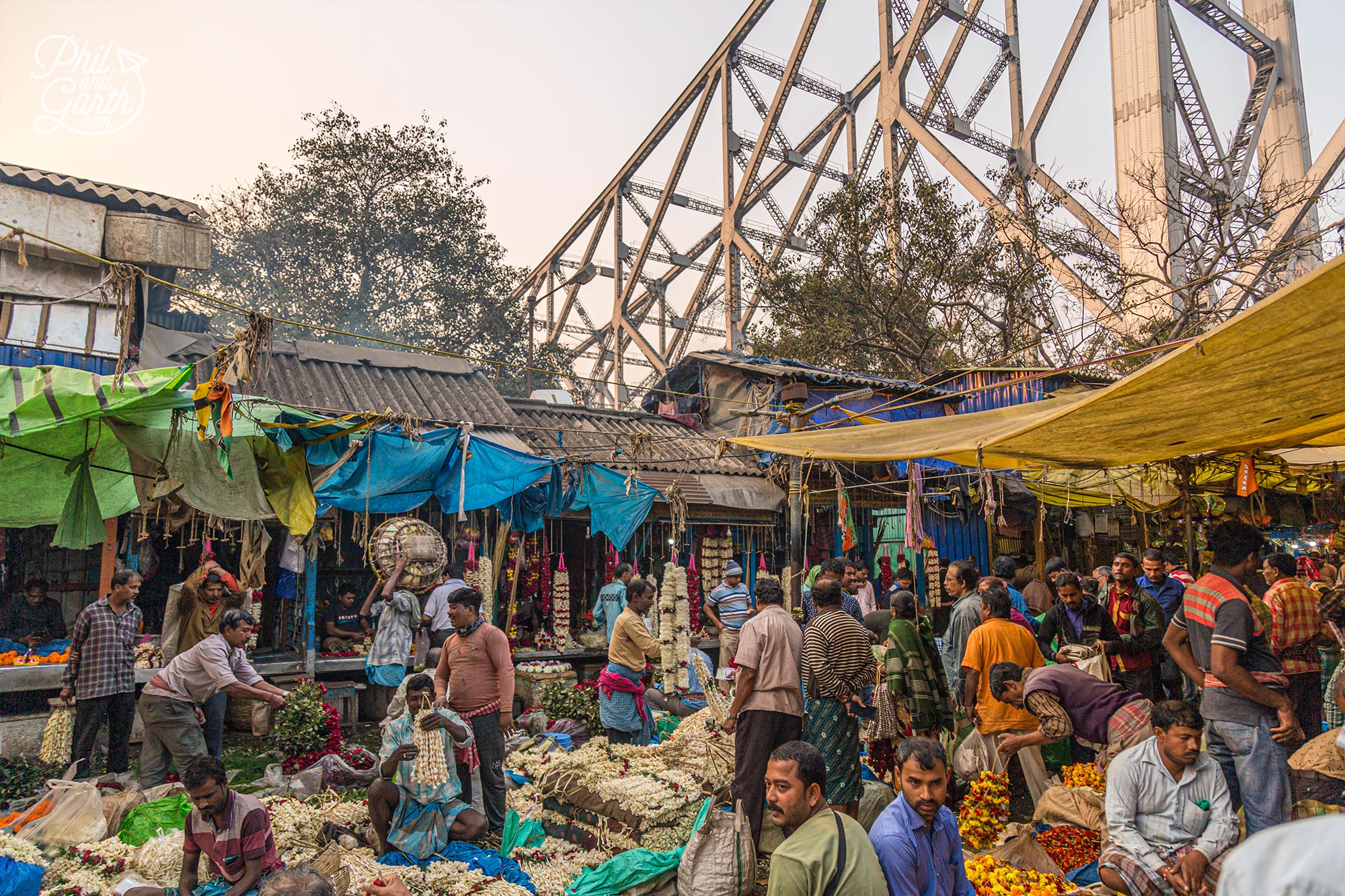 Walk up the stairs to the Howrah Bridge to observe the action from a different perspective