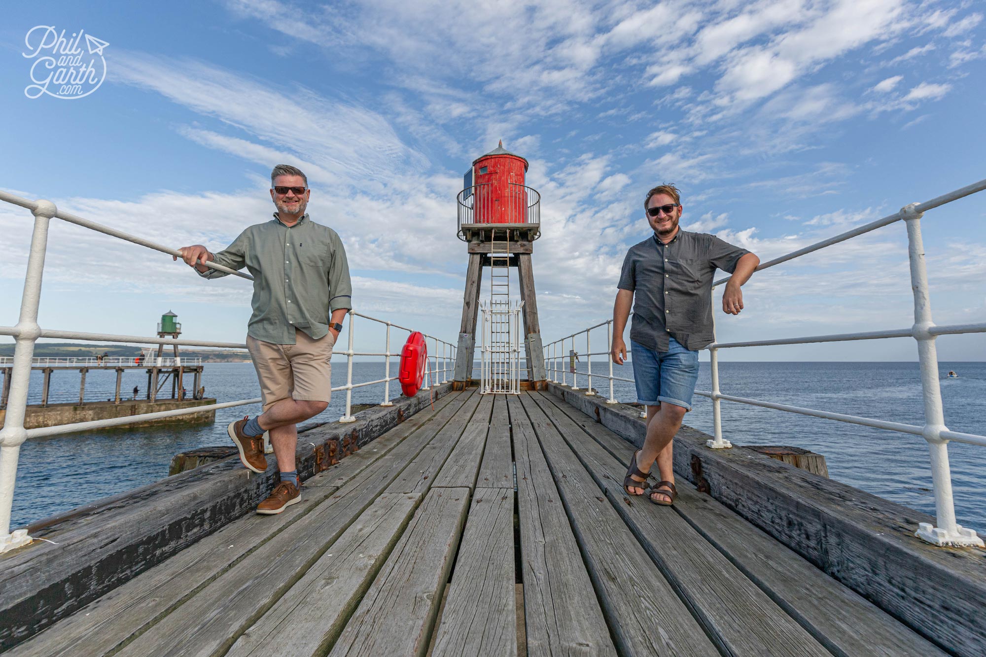 Phil and Garth standing on the wooden planks of the East Pier Whitby England