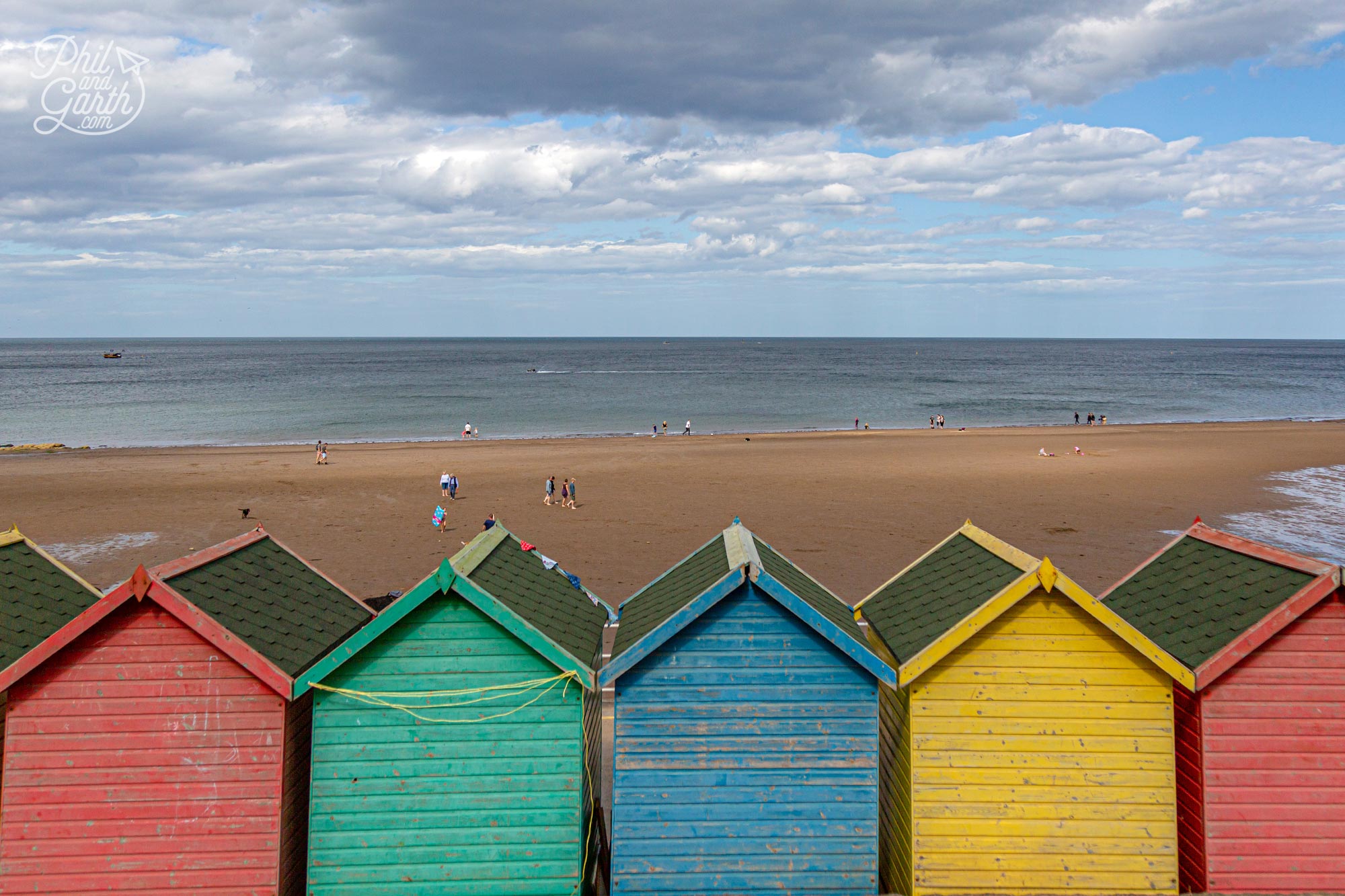 Rows of colourful beach huts along the promenade at Whitby Beach