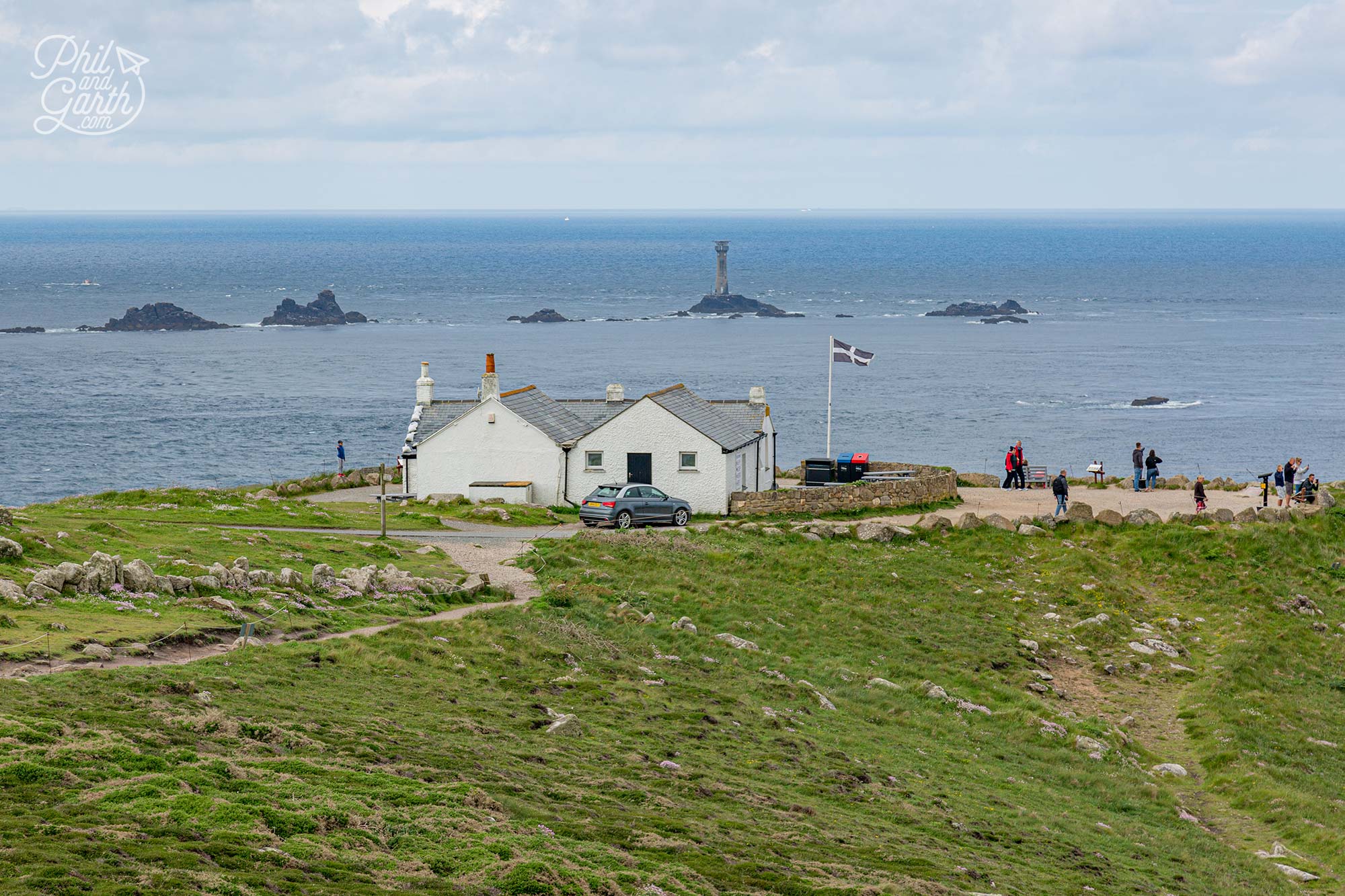 The first or last house with the rocky outcrops and Longships Lighthouse in the distance