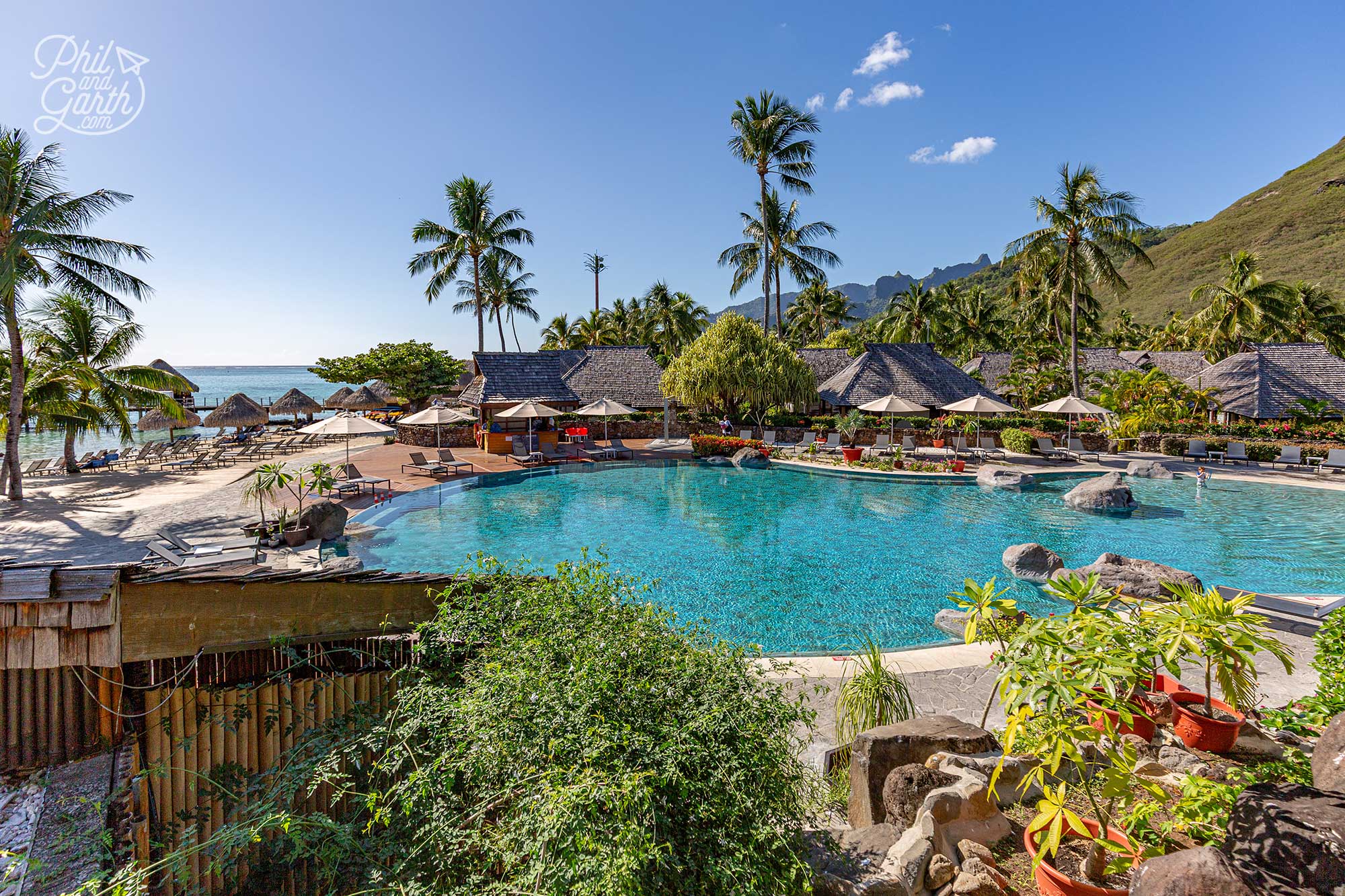 The swimming pool at Hilton Moorea, overlooking the lagoon’s crystal-clear water and lush green mountains in the distance
