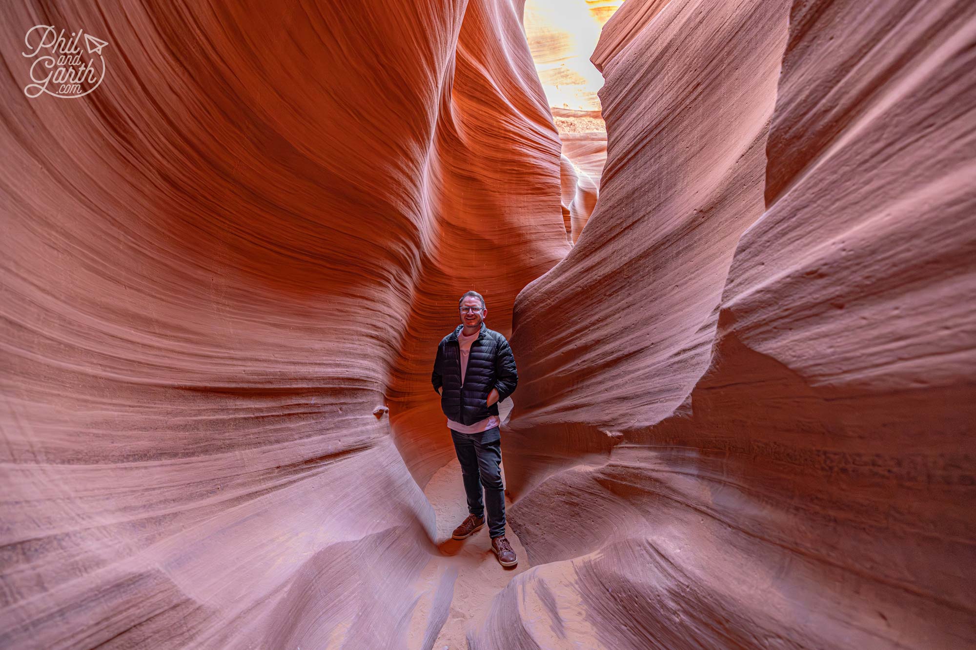 Garth walking further through swirling sandstone walls inside Antelope Canyon