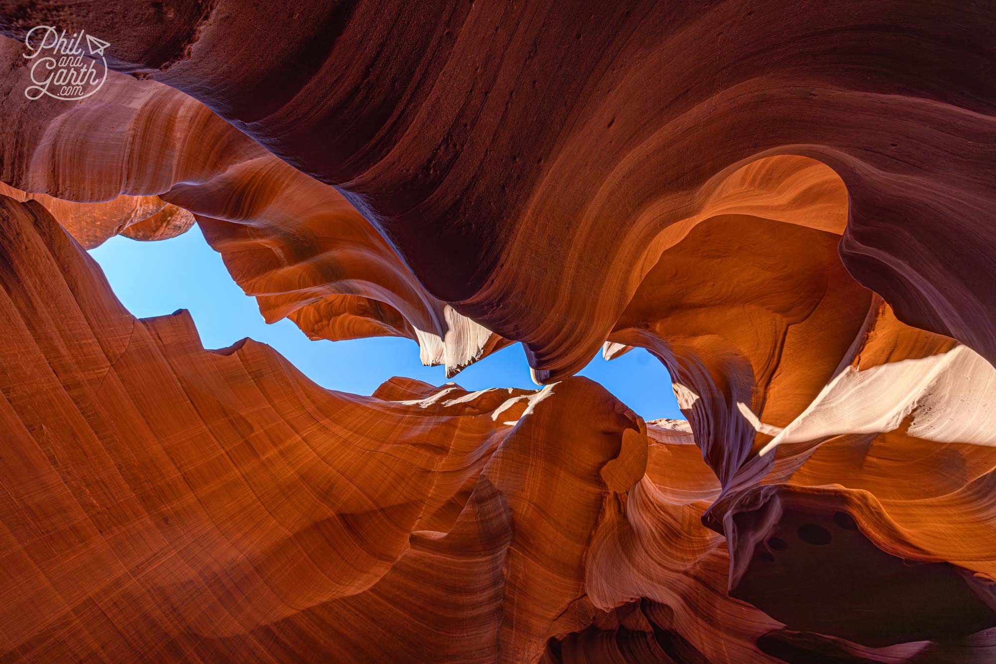 Looking up to the sunlight illuminating the orange sandstone walls of Antelope Canyon