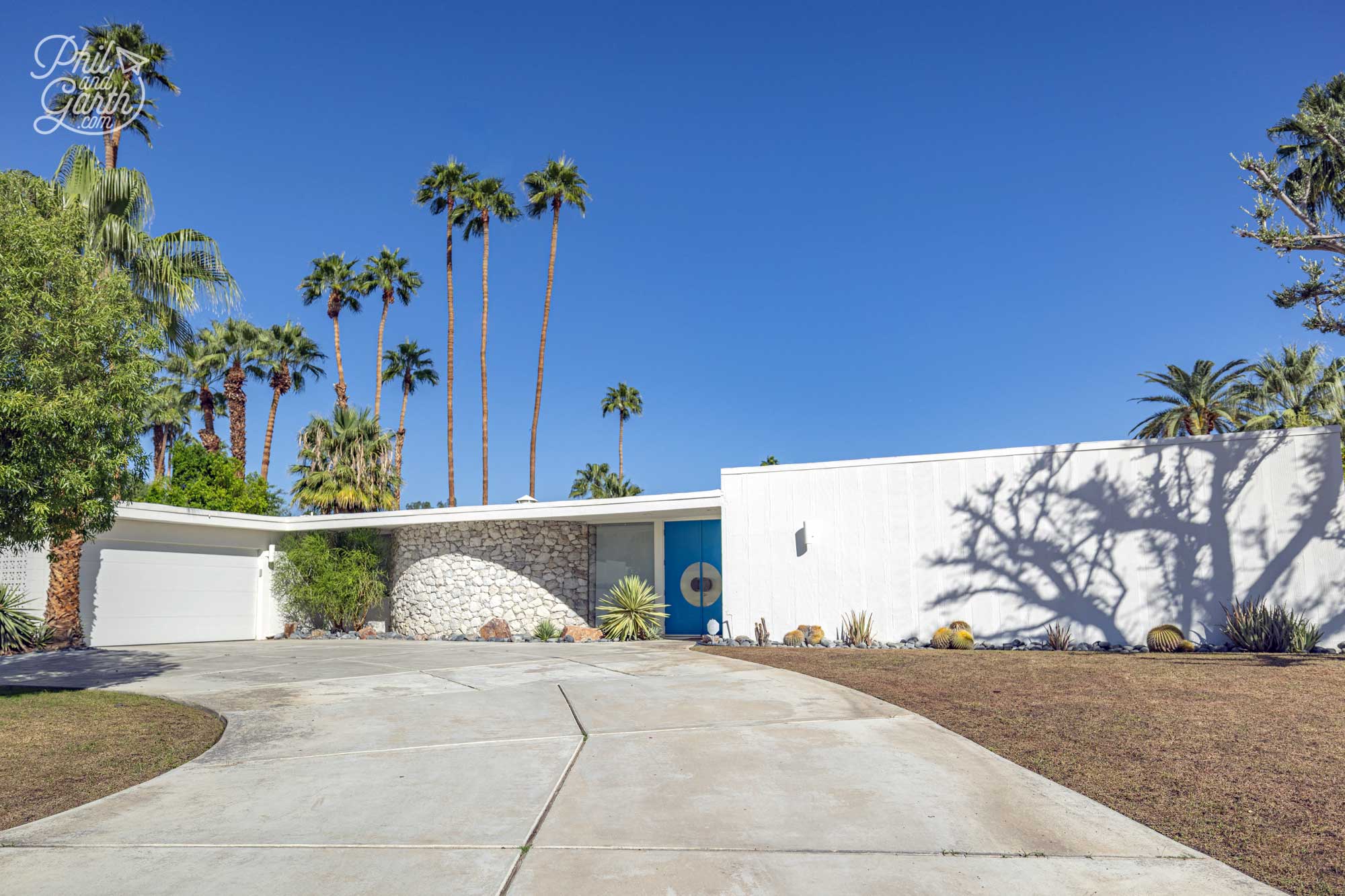 Movie Colony, Palm Springs - love the curved stone wall and vibrant blue double doors of this home