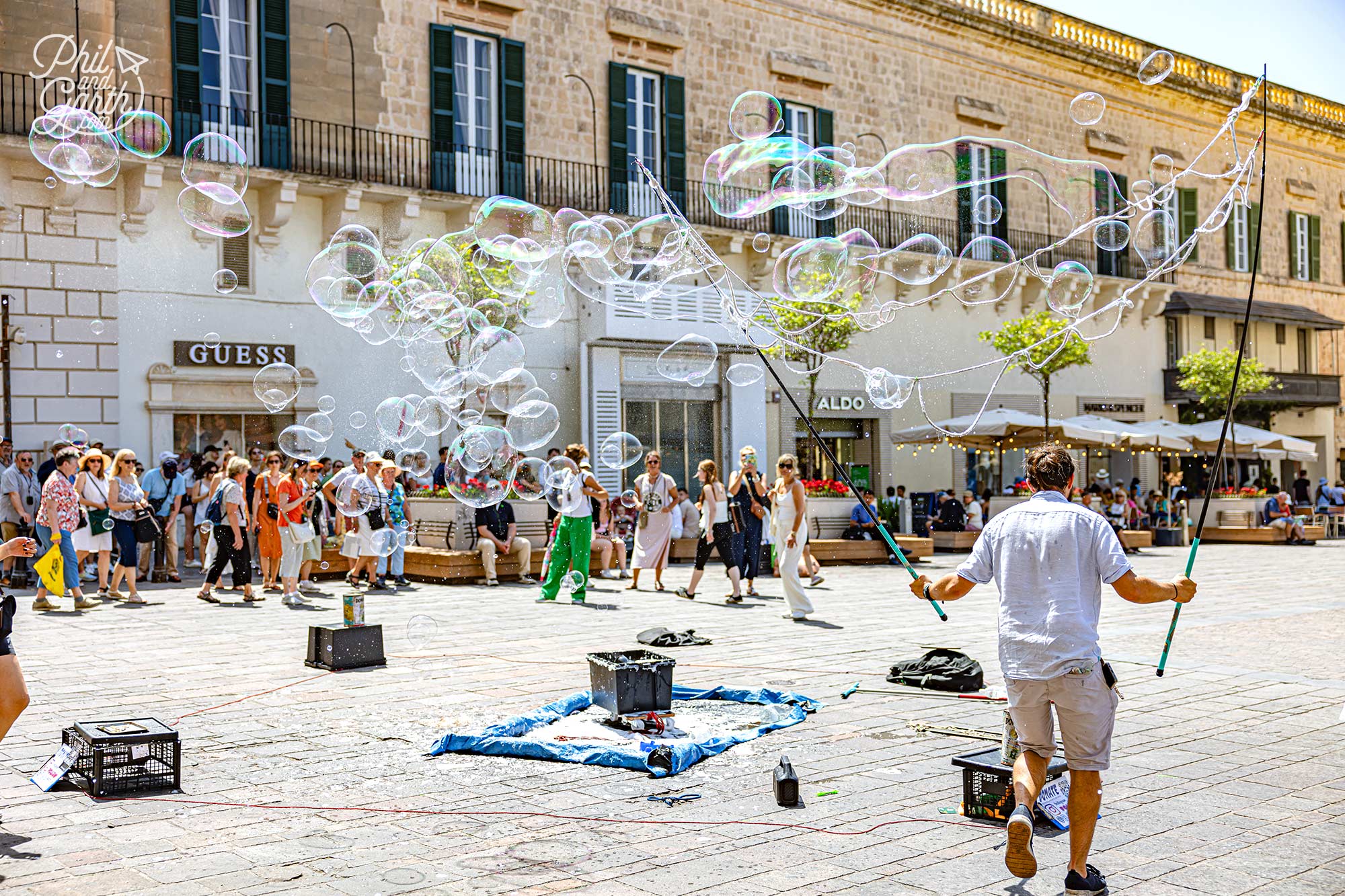Stopping to watch this talented street performer filling the square with giant bubbles