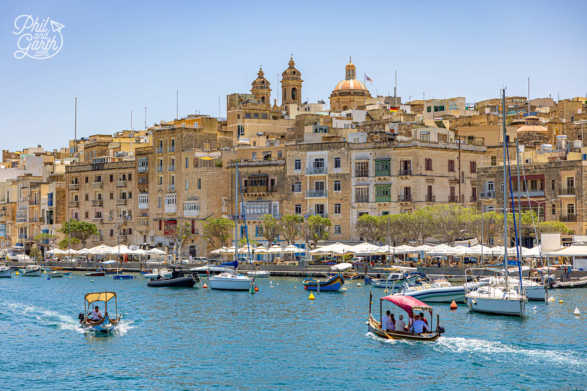 Traditional Maltese boats gliding past Senglea's historic waterfront
